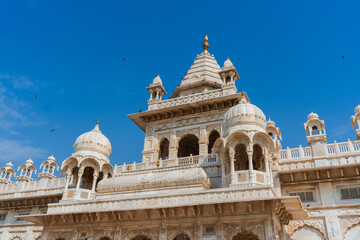 Obraz premium Beautiful view of Jaswant Thada cenotaph, Jodhpur, Rajasthan, India. Built out of intricately carved sheets of Makrana marble, they emit a warm glow when illuminated by the Sun. Blue sky background.