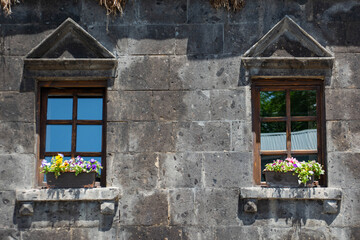 Beautiful windows and flowers on the windowsill. Beautiful house