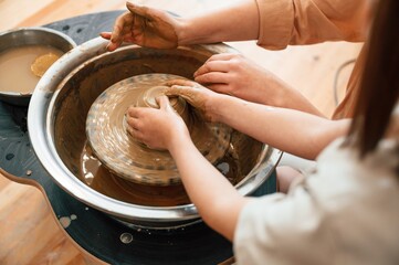 Close up view. Mother with little girl doing pottery at home