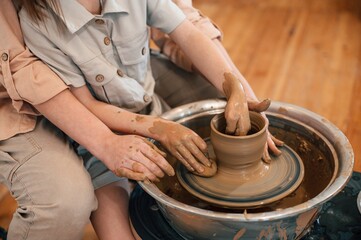 Close up view. Mother with little girl doing pottery at home