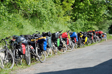 Fahrradtour macht Pause: Viele Fahrräder mit Gepäck stehen in einer Reihe im grünen Mai. in Damme