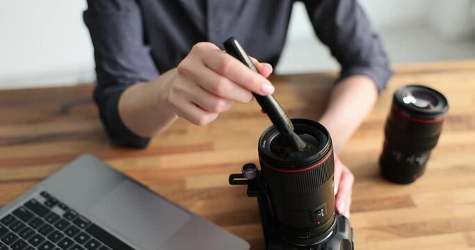 Cleaning lens of digital camera from dust with special pen for cleaning lenses. Care of photographic equipment and cleaning camera lens