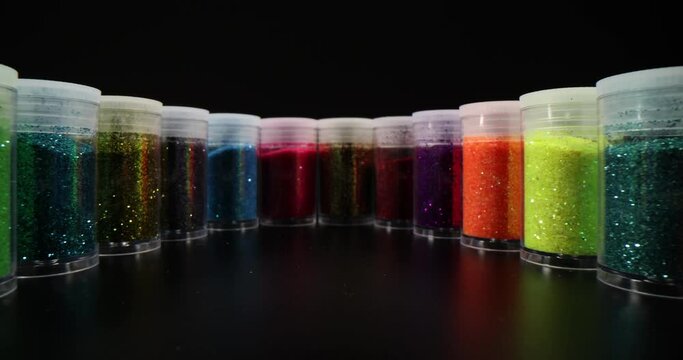 Different jars with beautiful shiny powder in row. Makeup glitter