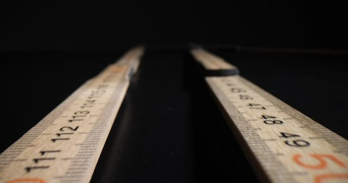Background of several wooden rulers placed in centimeters and millimeters. Folding wooden ruler