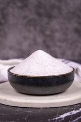 Non-iodized salt on dark background. Natural minaret non-iodized grinding salt in bowl. Spice concept. Close up
