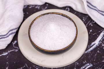 Non-iodized salt on dark background. Natural minaret non-iodized grinding salt in bowl. Spice concept