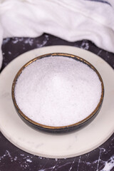 Non-iodized salt on dark background. Natural minaret non-iodized grinding salt in bowl. Spice...