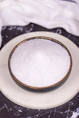 Non-iodized salt on dark background. Natural minaret non-iodized grinding salt in bowl. Spice concept