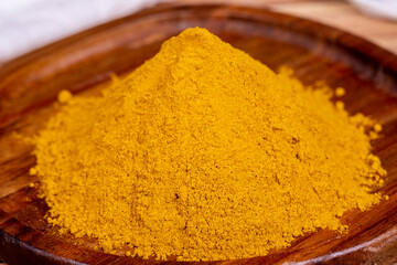 Curry powder on wooden background. Curry powder in wooden bowl. Mixture of spices and dried herbs....