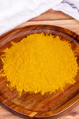 Curry powder on wooden background. Curry powder in wooden bowl. Mixture of spices and dried herbs. Spice concept
