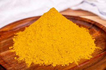Curry powder on wooden background. Curry powder in wooden bowl. Mixture of spices and dried herbs....