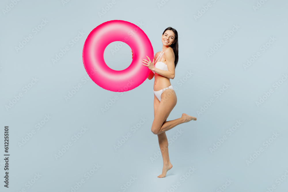 Wall mural full body side view fun young sexy woman wear swimsuit hold pink inflatable rubber ring near hotel p - Wall murals