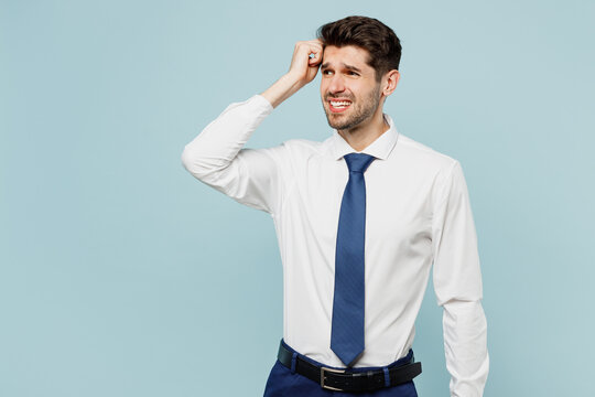 Young Mistaken Employee Business Man Corporate Lawyer Wear Classic Formal Shirt Tie Work In Office Look Aside Scratch Head Rub Temples Isolated On Plain Pastel Light Blue Background Studio Portrait.