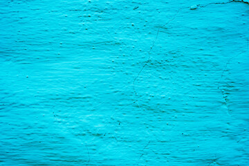 Turquoise textured wall with blue background, no people.