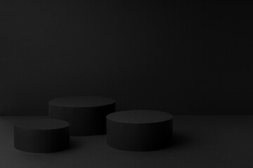 Abstract black scene with three cylinder podiums template for presentation cosmetic products, goods, advertising, design, sale, card, poster, text, flyer in soft gradient, mockup in minimalism style.