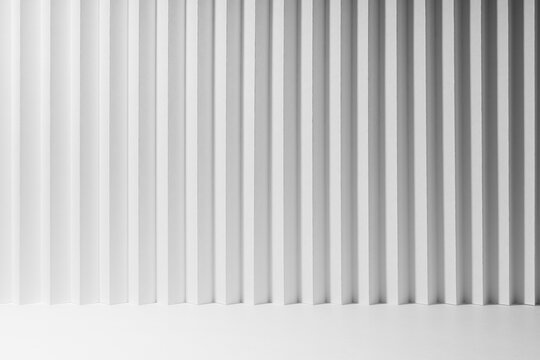 White abstract background of vertical folded striped gradient pattern, perspective, floor as stage mockup for presentation cosmetic products, goods, advertising, design, soft light modern urban style.