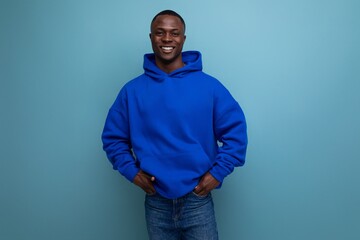 close-up of a laughing black american man in a sweatshirt with a hood on a studio background with...