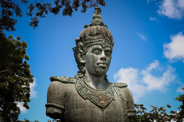 Fototapeta na wymiar A large copper statue of Wisnu's torso and head at the GWK Cultural Park in Bali, Indonesia