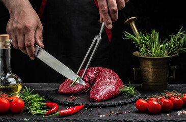 Fresh and raw beef meat. Whole piece of tenderloin with steaks and spices ready to cook on dark background, banner, menu, recipe place for text, top view