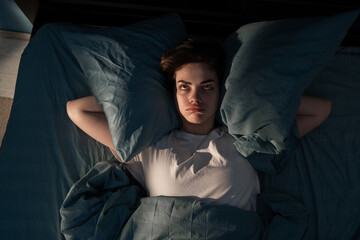 Annoyed woman suffering neighbour noise in the bedroom at night at home. She can't sleep at night....