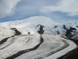 Aerial panoramic view of the Main Caucasus Mountain Ridge from Mount Elbrus, the highest summit in Europe, glacier Seven, incredible blue sky background, impressive nature landscape in North Caucasus