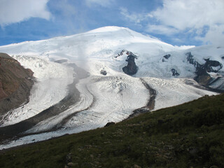 Aerial panoramic view of the Main Caucasus Mountain Ridge from Mount Elbrus, the highest summit in Europe, glacier Seven, incredible blue sky background, impressive nature landscape in North Caucasus