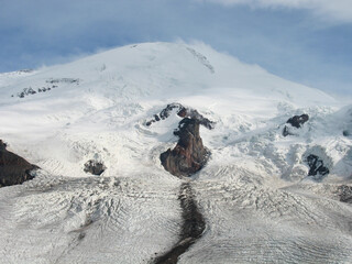 Aerial panoramic view of the Main Caucasus Mountain Ridge from Mount Elbrus, the highest summit in Europe, glacier Seven, incredible blue sky background, impressive nature landscape in North Caucasus