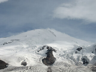 Aerial panoramic view of the Main Caucasus Mountain Ridge from Mount Elbrus, the highest summit in Europe, glacier Seven, incredible blue sky background, impressive nature landscape in North Caucasus