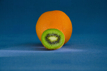 Orange and half kiwi on a blue background