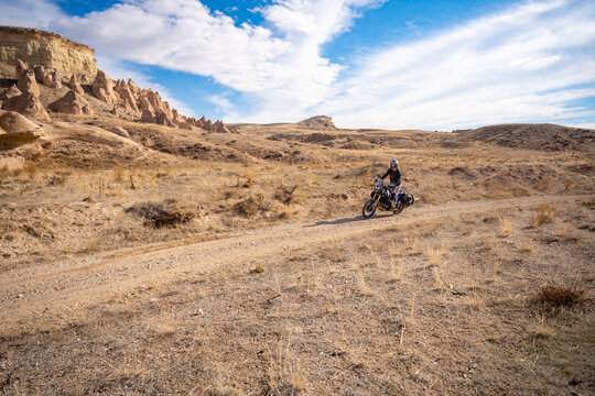 Motorcyclist riding in landscape with special rock formations in Cappadocia, Turkey