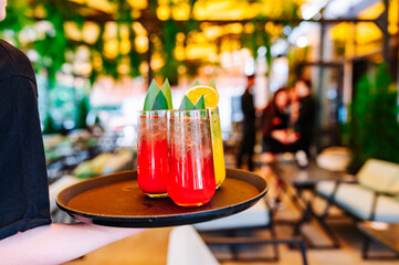 glasses alcohol cocktail set on a waiter tray in bar