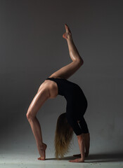 Flexible sexy girl dancing. Beautiful flexible woman body. Fashion art studio portrait of fit sexy flexible woman on black. Gymnastic slim and flexible dancer woman performing. Stretches exercise.