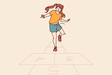 Little girl plays hopscotch jumping on cages drawn on pavement asphalt on summer sunny day. Happy teenage girl leads active lifestyle and playing hopscotch in free time from school
