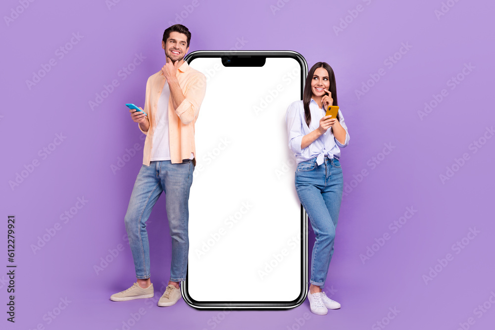 Poster full length portrait of two minded funny people hold smart phone look curious empty space isolated o