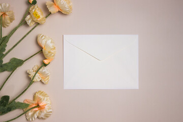 A white envelop with flowers over the pick background. 