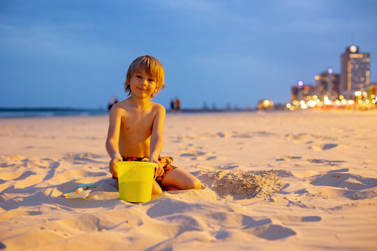 Child, boy, playing on the beach in Tel Aviv in the evening