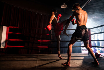 Asian and Caucasian Muay Thai boxer unleash knee attack in fierce boxing training session,...