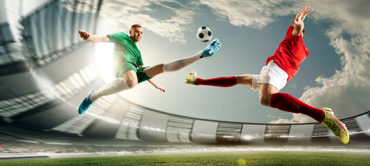 Bottom view of two football players in motions during game at 3D openair playground, arena on daytime. Kicking ball in jump. Concept of professional sport, championship, game, achievement
