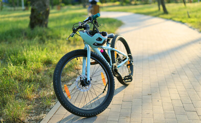 Fototapeta premium Children's bike with a helmet on the cycle path in the park.