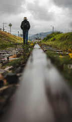 Obraz premium A young traveler walking along railroad tracks