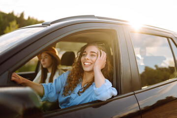 Two young women on car trip having fun. Lifestyle, travel, tourism, nature, active life.