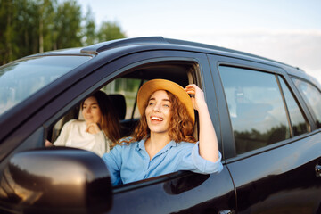 Two young women on car trip having fun. Lifestyle, travel, tourism, nature, active life.