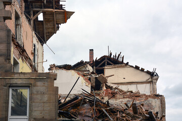 Houses destroyed as a result of military shelling against the background of the sky. View from below