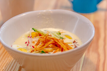 Light diet soup with fresh cucumbers, seasoned with yogurt in bowls on light background. Traditional Russian dish - 