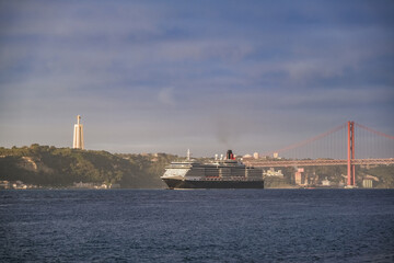 Luxury ocean liner cruiseship cruise ship Victoria or Elizabeth in port of Lisbon, Portugal during Mediterranean cruising with city skyline, Christos statue and suspension bridge