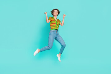 Fototapeta na wymiar Full length photo of overjoyed energetic person jumping raise fists isolated on teal color background