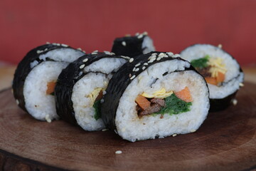 Sushi roll with carrots, eggs, meat and spinach