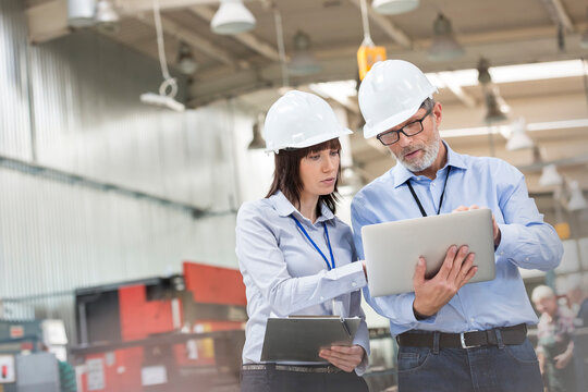 Engineers with laptop in factory