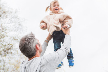Father lifting toddler daughter overhead