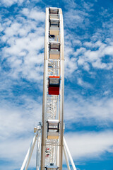 A tall Ferris wheel in the park against a blue sky